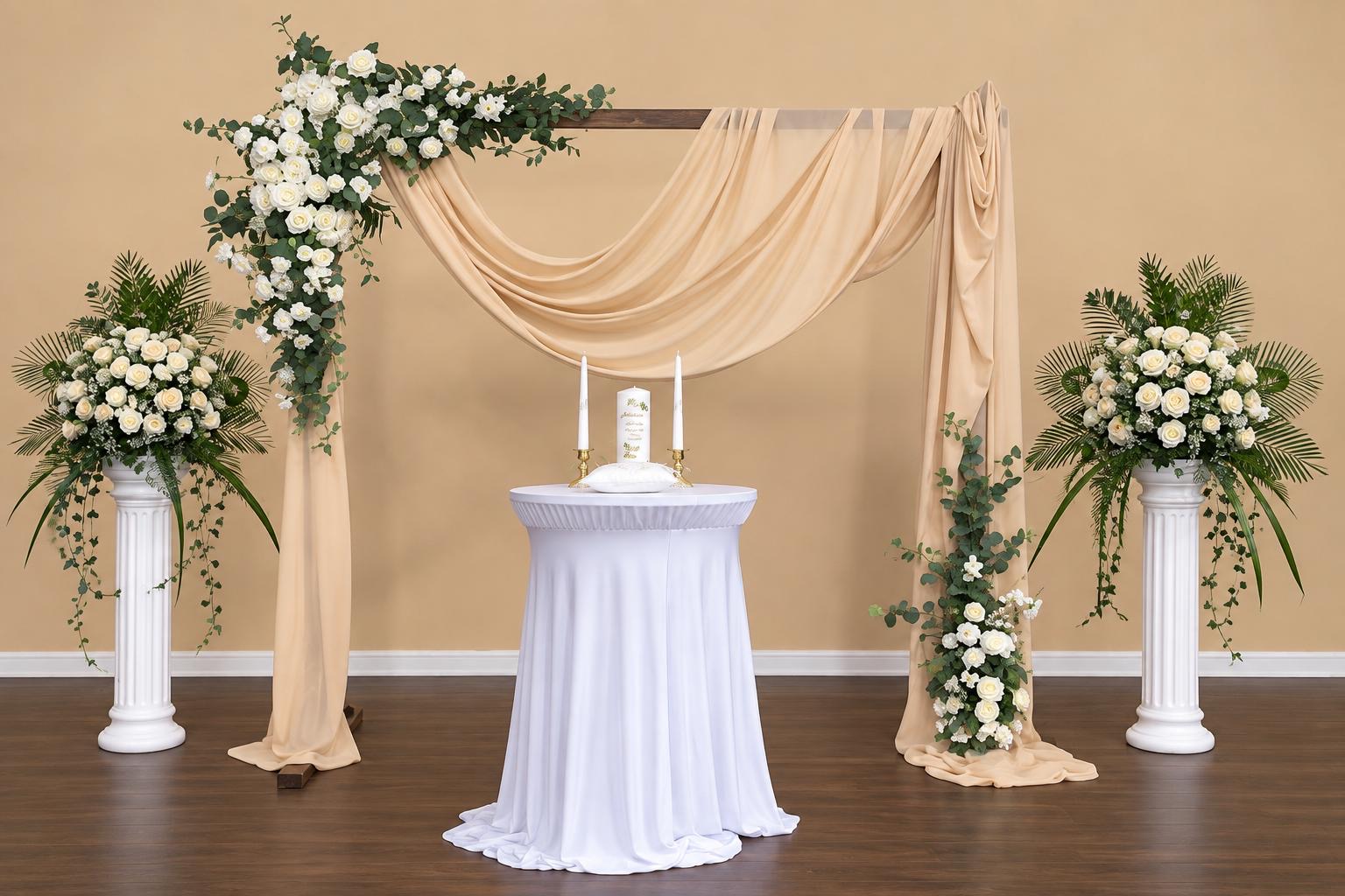 Champagne draped ceremony backdrop with white flowers and greenery