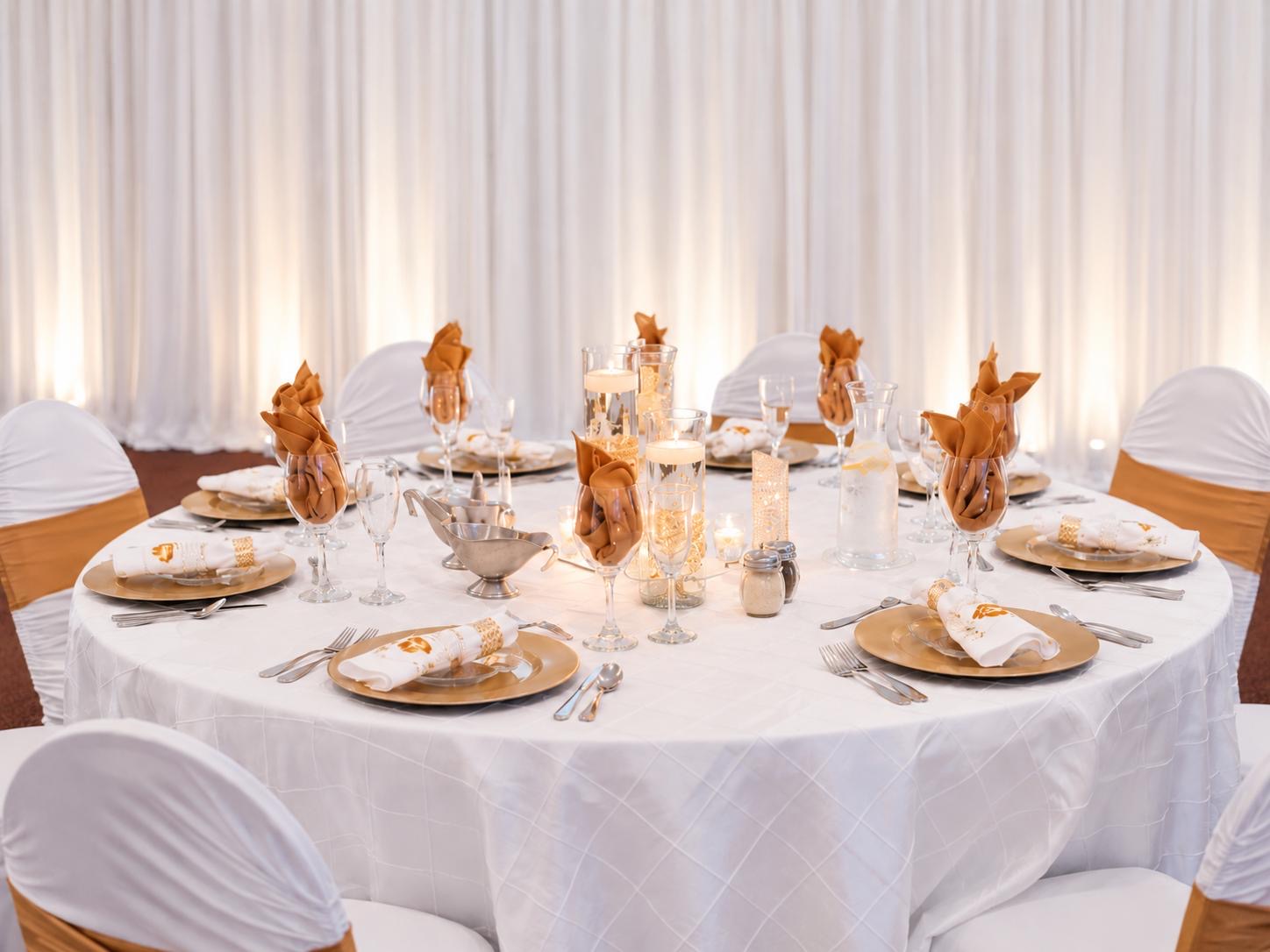 White and gold wedding table setting with candle centerpieces