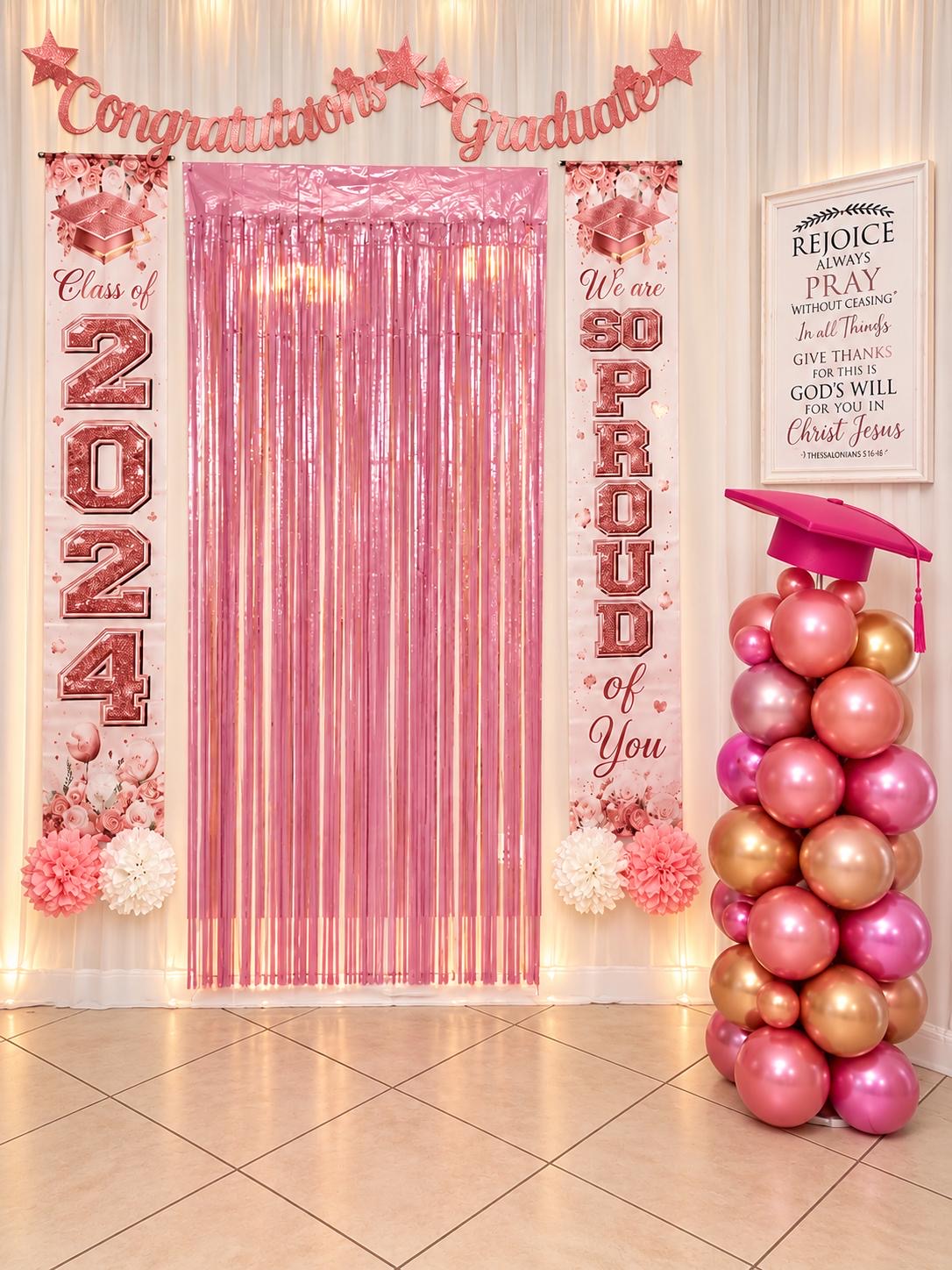Pink graduation photo backdrop with class-year decorations and balloon column