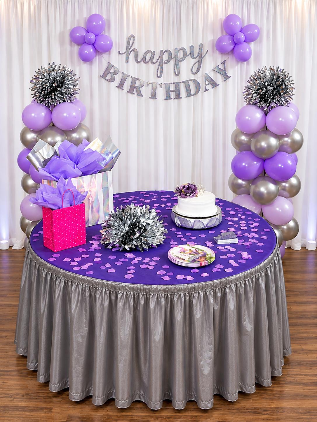 Purple and silver birthday table with balloon columns and gift boxes